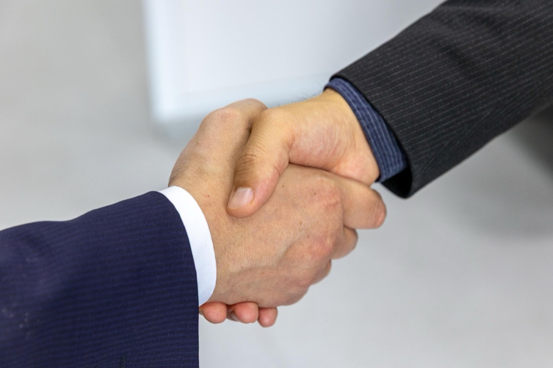 Two professionals shaking hands to close a C-store deal